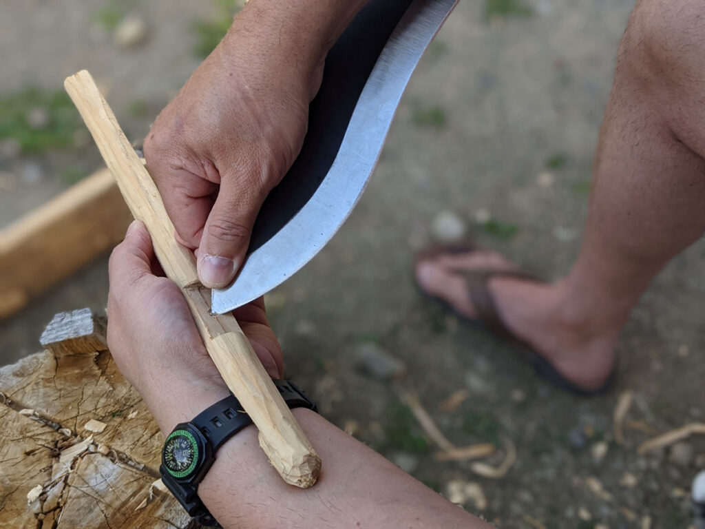Jaime de la Parra holding the SLYSTEEL Survival Kukri by blade spine near the knife tip, a big survival knife, to make a try stick knife tip mortice. Photograph by Brandon Barlow.