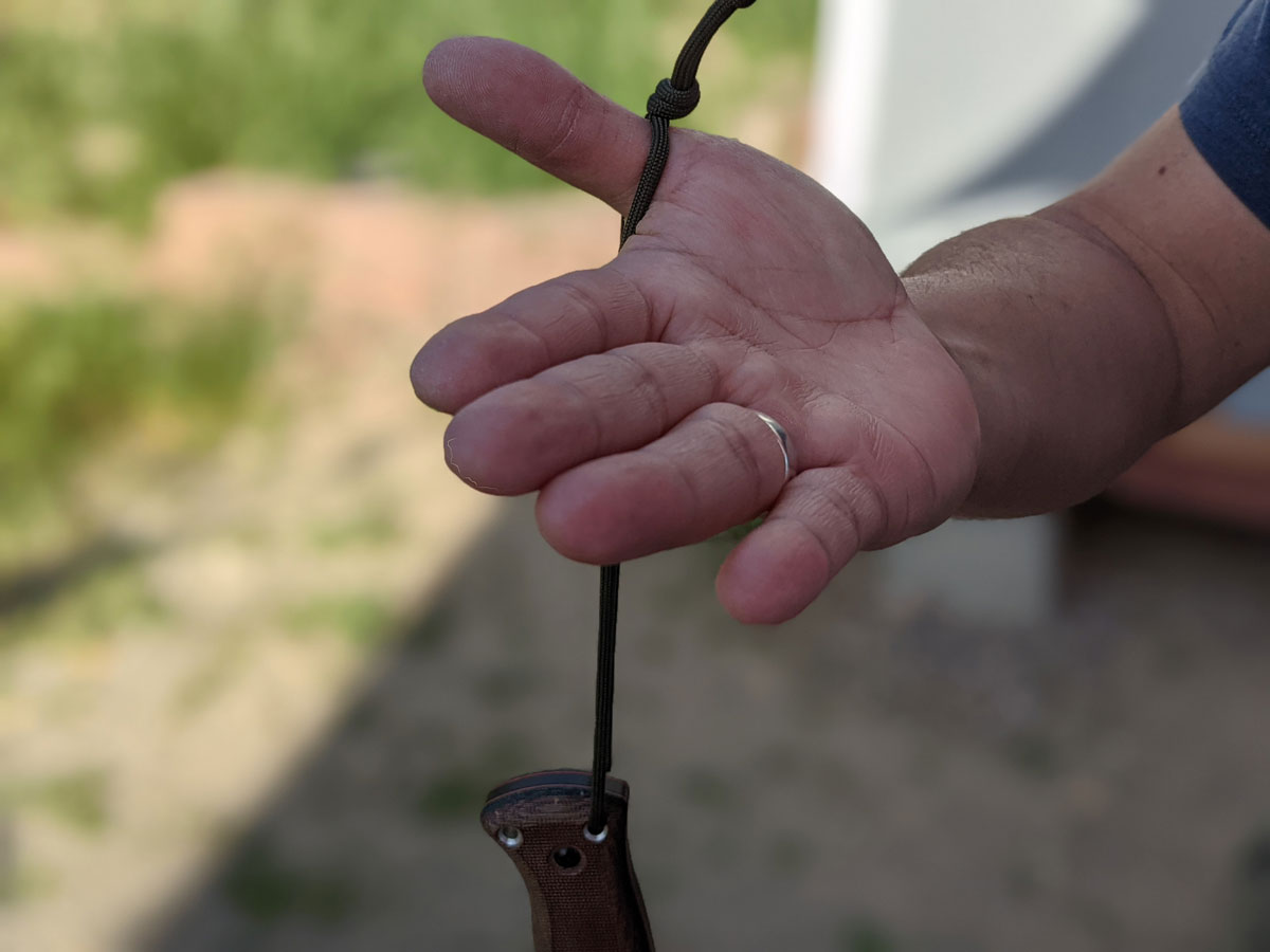 Jaime de la Parra dangling the SLYSTEEL Survival Kukri from his thumb by the lanyard hole and loop. Photograph by Brandon Barlow.