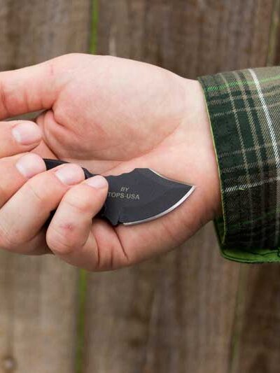 A photograph of a dual edge Final Option Blade cupped in hand for concealment.